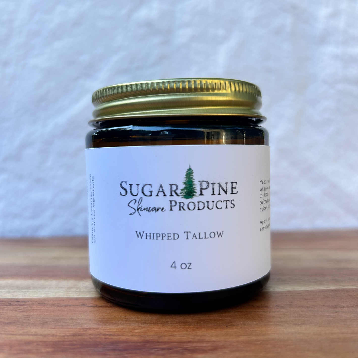 Jar of Sugar Pine Products whipped tallow on a wooden surface with a white background