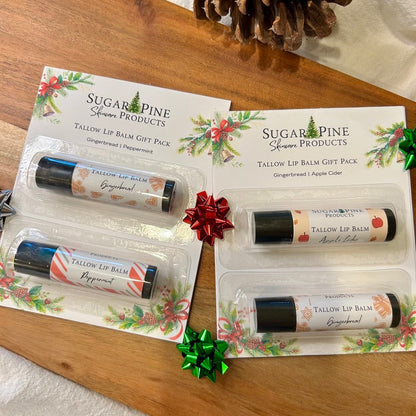 Two packages of Sugar Pine Tallow Lip Balm Gift Packs on a wooden surface with decorative bows.
