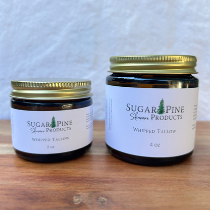Two jars of Sugar Pine Products whipped tallow on a wooden surface with a white background