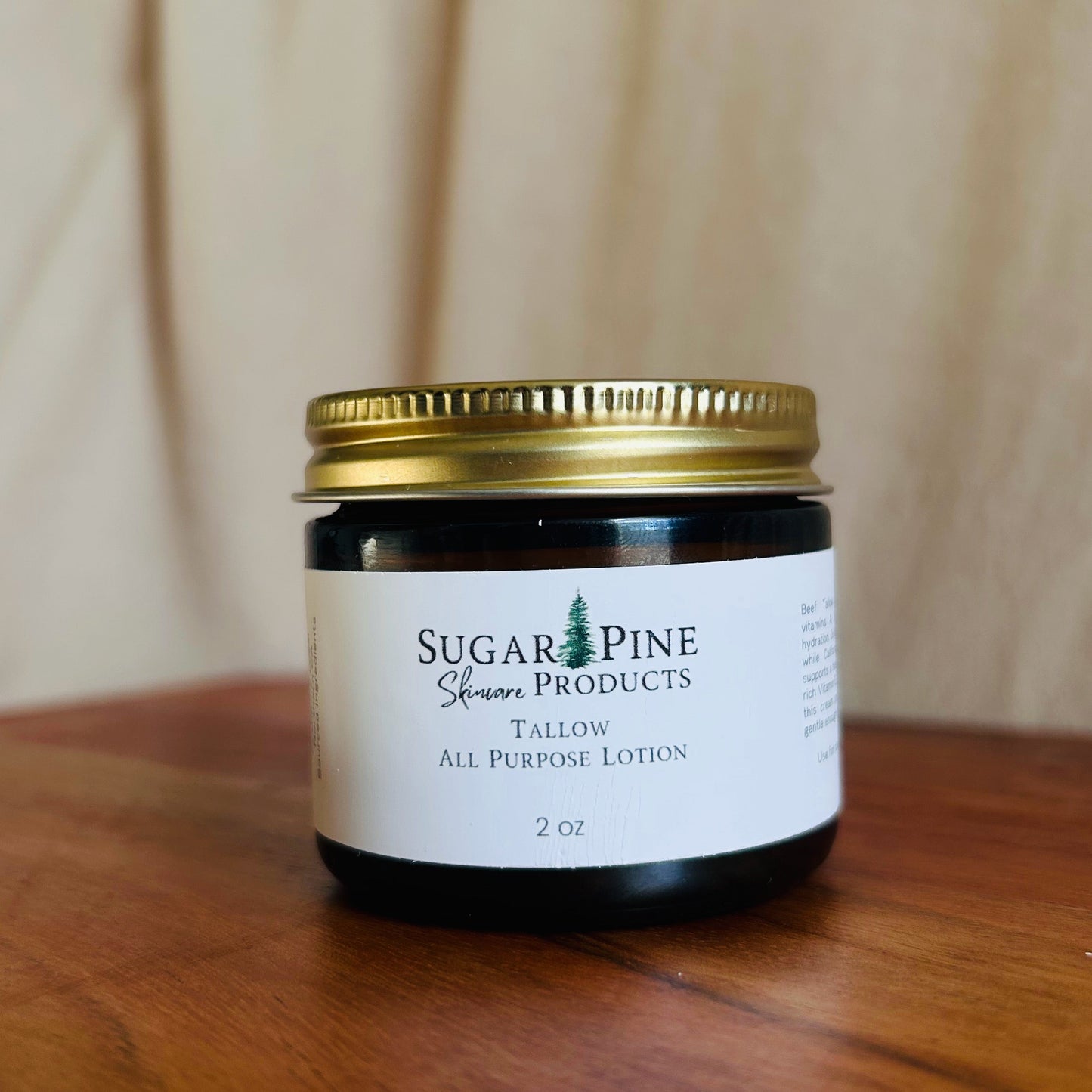 Small jar with a gold lid on a wooden surface sugar pine products all purpose tallow lotion