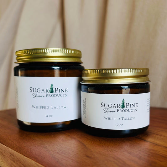 Two WHIPPED TALLOW JARS FRMO SUGAR PINE PRODUCTS with gold lids on a wooden surface