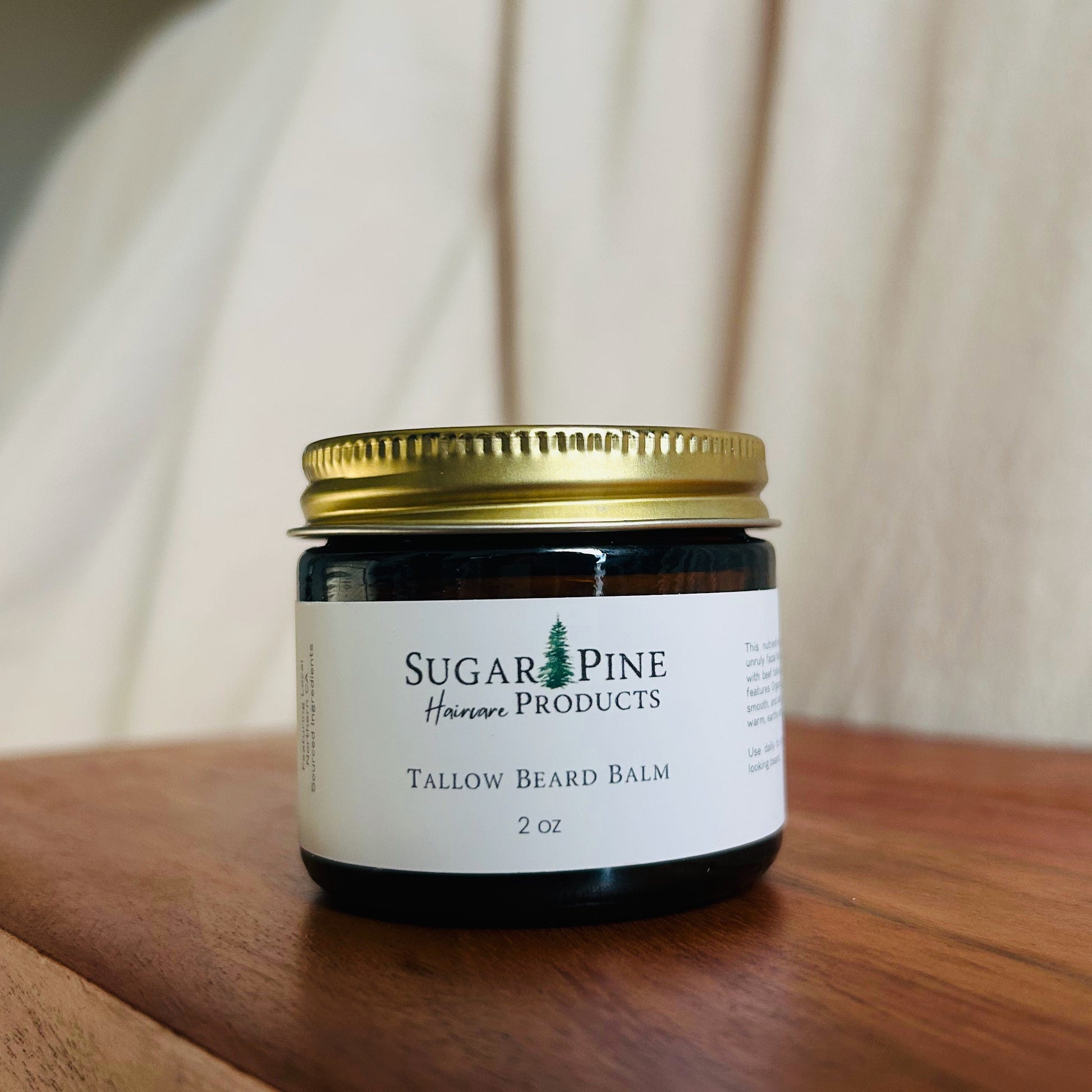 Small jar with a gold lid on a wooden surface sugar pine products tallow beard balm